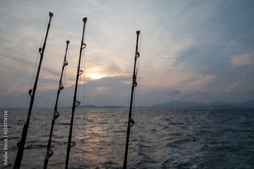 trolling rods and reels for sea fishing on a boat against the sea