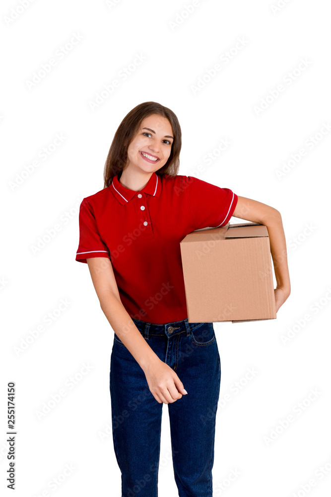 Happy young delivery girl in a red T-shirt is holding a carton parcel box under her arm isolated on white background Happy young delivery girl in a red T-shirt is holding a carton parcel box under her arm isolated on white background
