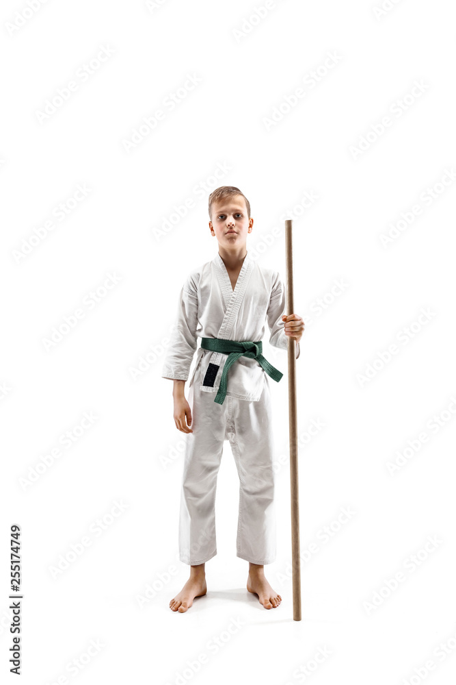 Teen boy fighting with wooden sword at Aikido training in martial arts school. Healthy lifestyle and sports concept. Fightrer in white kimono on white background. Karate man in uniform. Teen boy fighting with wooden sword at Aikido training in martial arts school. Healthy lifestyle and sports concept. Fightrer in white kimono on white background. Karate man in uniform.