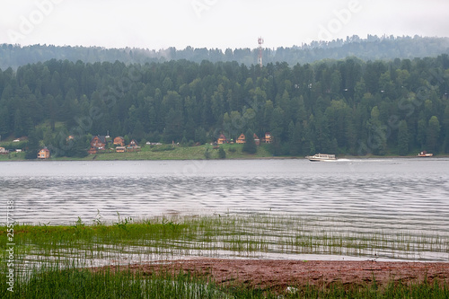 summer landscape on a mountain lake. fog over forest. ships and boats floating near the shore on the water © Lyubov Furs