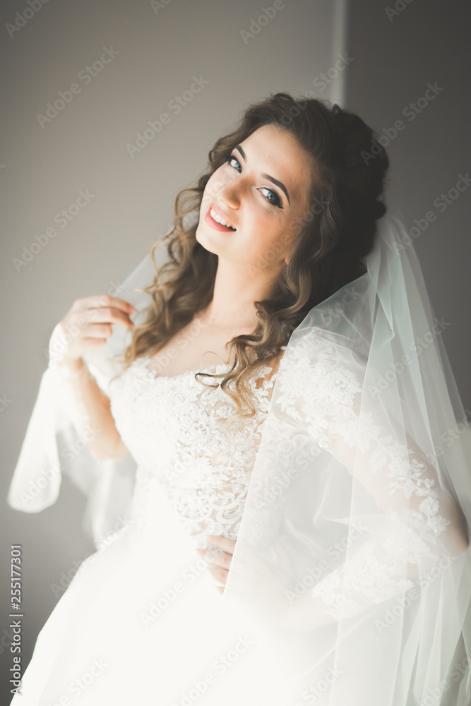 Luxury bride in white dress posing while preparing for the wedding ceremony Luxury bride in white dress posing while preparing for the wedding ceremony