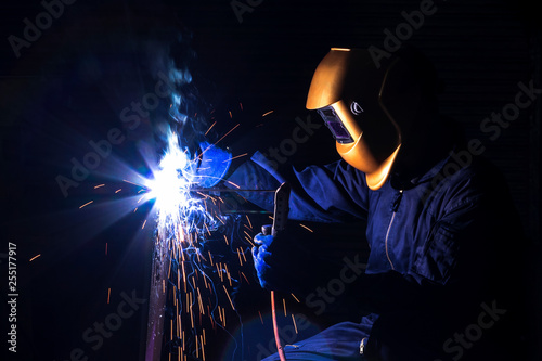 A craftman is welding with workpiece steel.Working person About welder steel Using electric welding machine There are lines of light coming out and safety equipment in factory industry..
