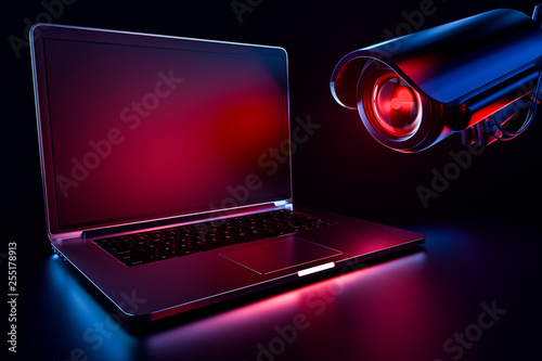Computer observed by hostile looking camera as a metaphor of stalking or malicious software observing and tracking user. Copy space on laptop screen included. 3D rendering