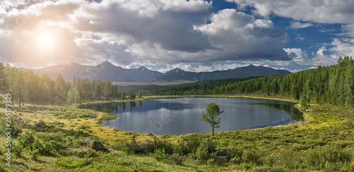 tourism and travel  summer landscape in Altai mountains  round small lake. white clouds in the blue sky are reflected in the water.