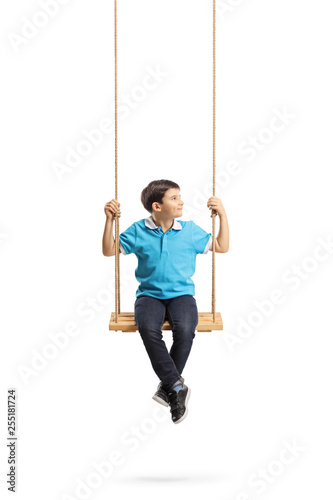 Little boy sitting on a swing and looking to the side
