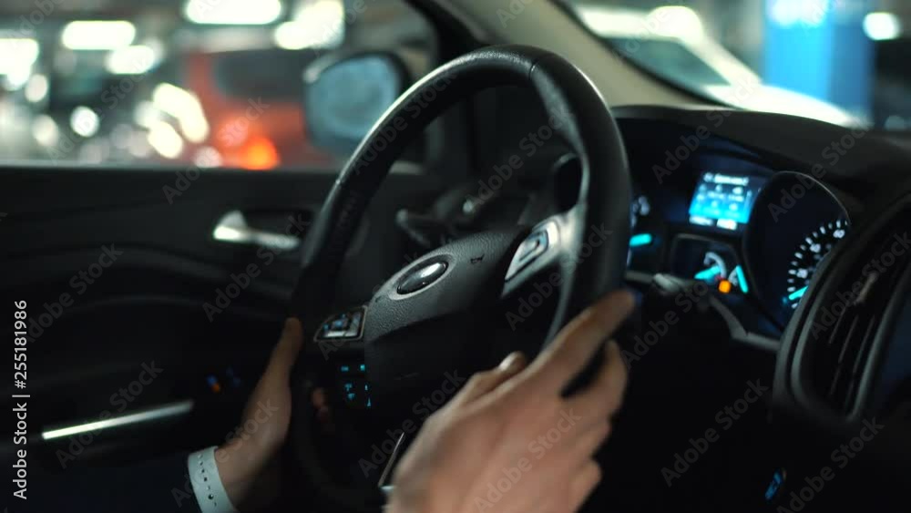Man driving in innovative automated car using self-parking autopilot for parking on street Man driving in innovative automated car using self-parking autopilot for parking on street
