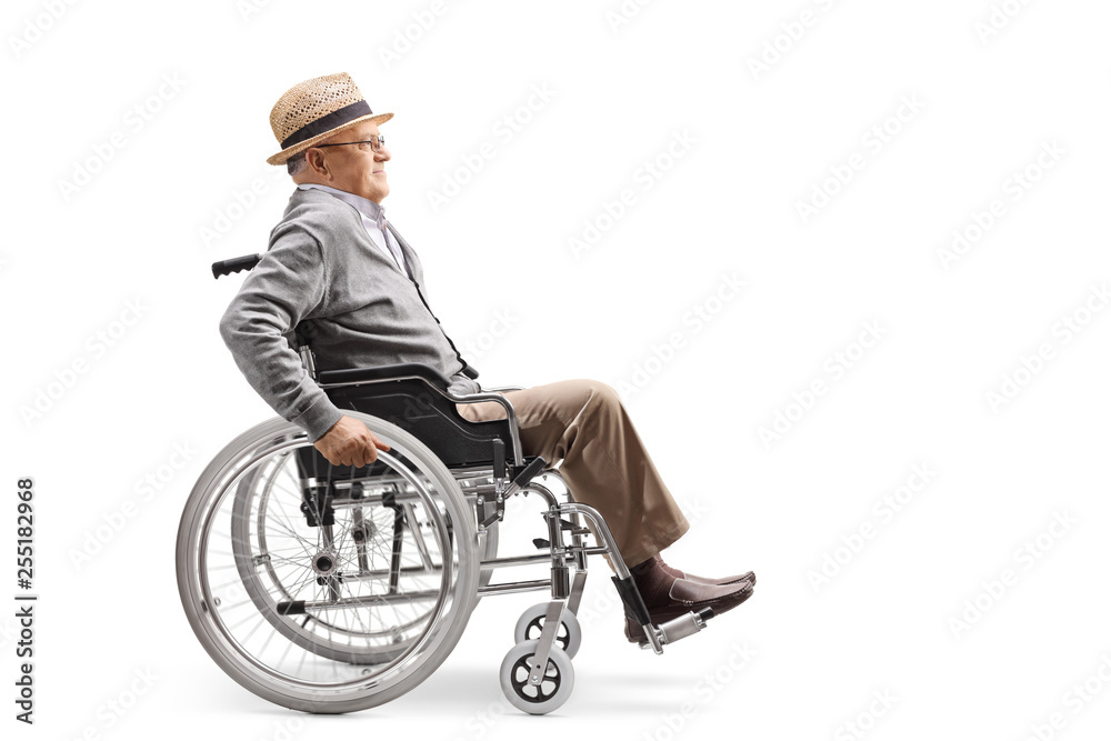Elderly man in a wheelchair pushing himself manually Elderly man in a wheelchair pushing himself manually