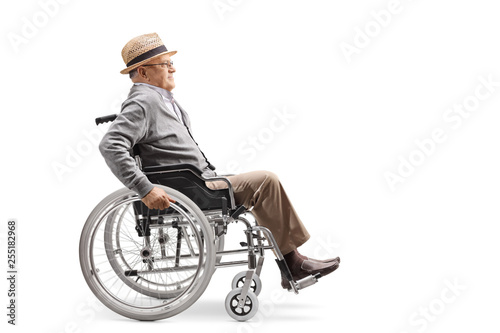 Elderly man in a wheelchair pushing himself manually