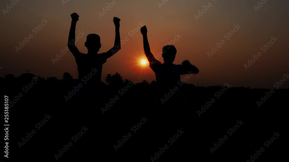 Asian teenagers and his brother are dancing happily at sunset. Asian teenagers and his brother are dancing happily at sunset.