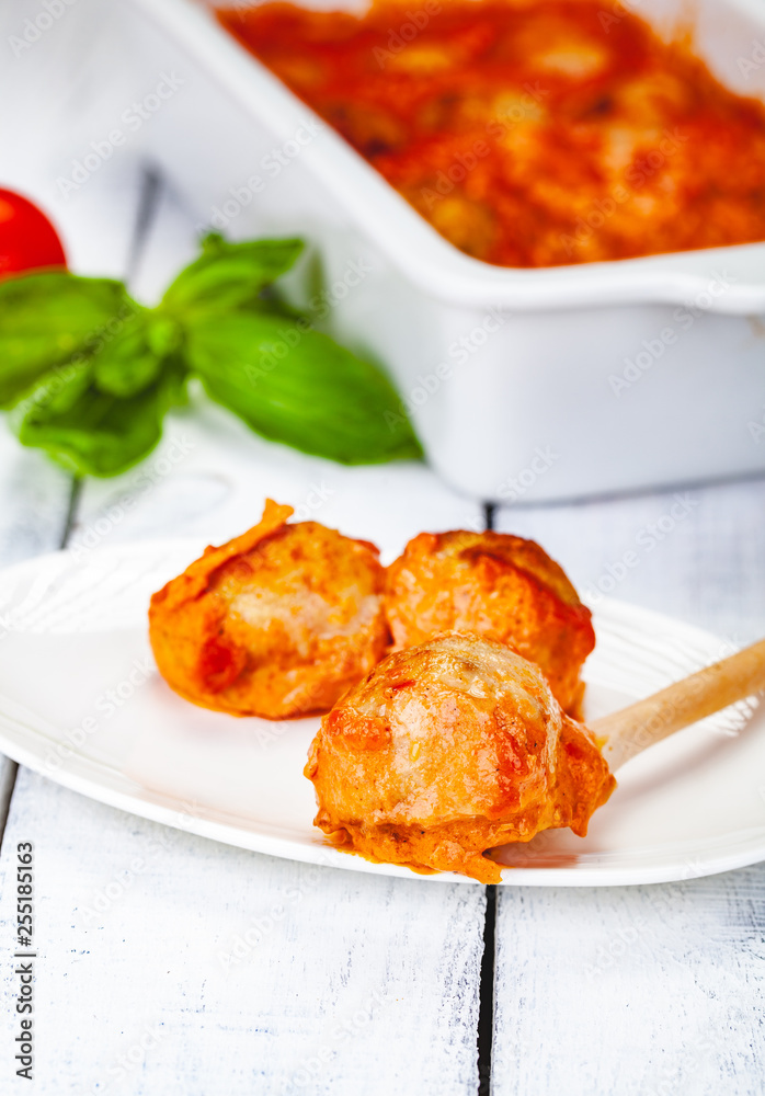Meatballs with tomato and sour cream sauce on white plate. Close up Meatballs with tomato and sour cream sauce on white plate. Close up