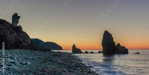 Nerja, Malaga, Andalusi, Spain - February 4, 2019: Sunrise on the coast with two large rocks on the shore of El Molino beach, Nerja coast, southern Spain