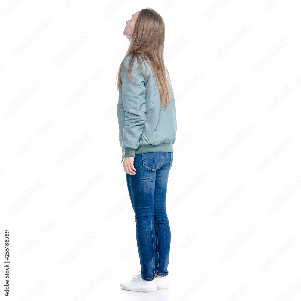 Woman in jeans and green jacket standing looking on white background isolation, back view Woman in jeans and green jacket standing looking on white background isolation, back view