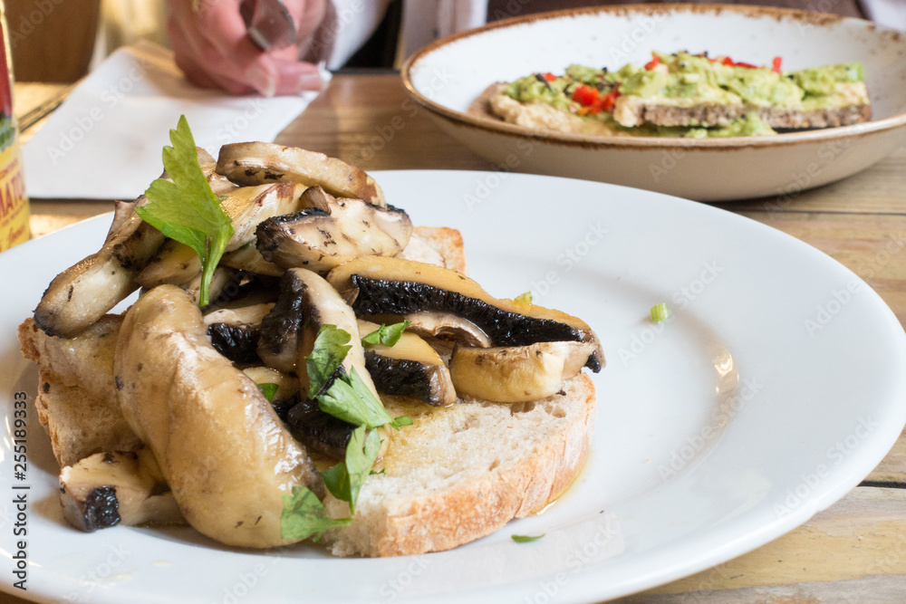 Healty vegan dishes of mushrooms on toast and avocado on toast