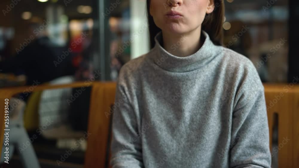 Woman eats a hamburger in a cafe Woman eats a hamburger in a cafe