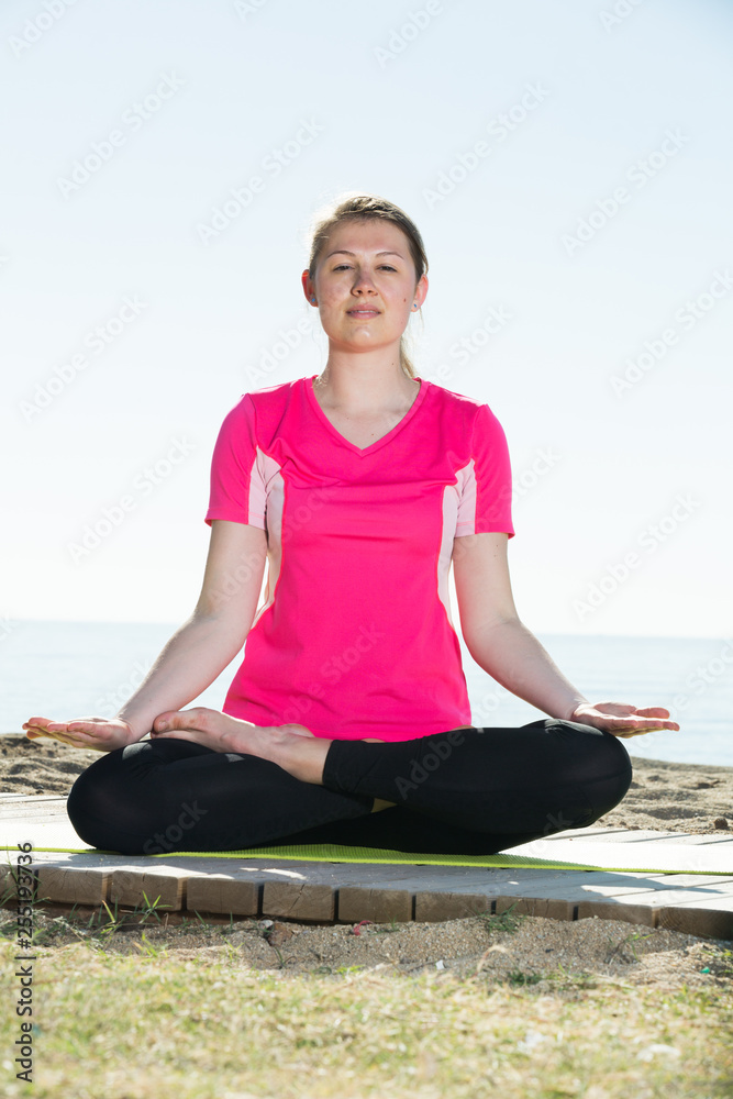 Woman training yoga poses on beach