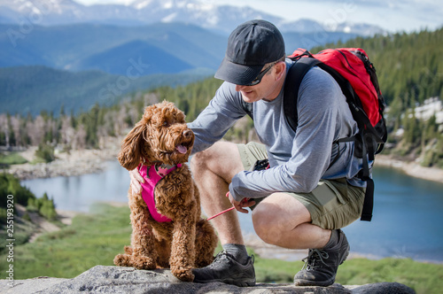 Dog catching breath with man on mountain hike