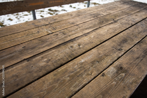 Empty wooden table with snow bokeh for a catering or food picnic texture