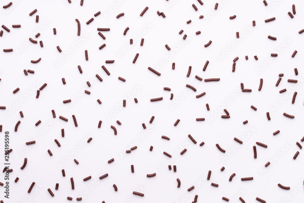 flat lay of chocolate sprinkles over white background like background, top view flat lay of chocolate sprinkles over white background like background, top view