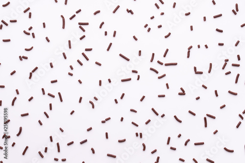 flat lay of chocolate sprinkles over white background like background  top view