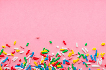 greeting background of colorful sprinkles over pink, festive invitation for Valentines day, birthday, holiday and party time, copy space