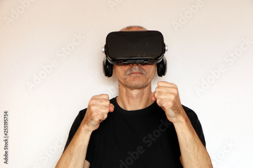 Close-up of a man in a black T-shirt with glasses of virtual reality.
