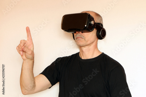 Close-up of a man in a black T-shirt with glasses of virtual reality.