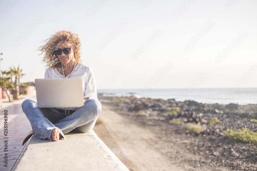Technology and travel. Working outdoors. Freelance concept. Pretty young woman using laptop  beach.