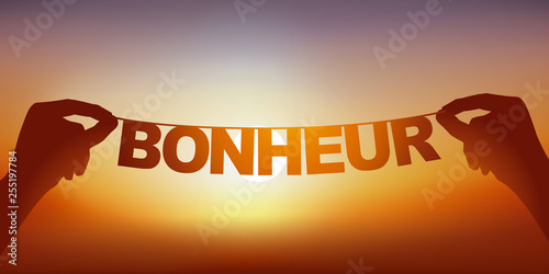 Concept du bien-être et de la joie de partir en vacances, avec deux mains qui tiennent une guirlande sur laquelle est écrit le mot bonheur devant un ciel ensoleillé.