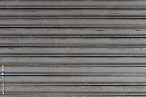 A closeup shot of automatic metal roller door used in factory, storage, garage, and industrial warehouse. The corrugated and foldable metal sheet offer space saving and provide urban and rustic feel