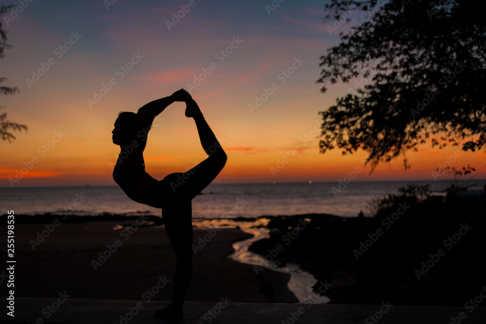 woman  silhouette playing yoga on sunset background