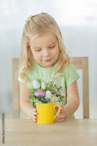 Cute little girl making decoration for Easter. Easter bouquet, eggs, easter, traditions. © Sviatlana