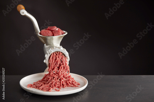 Meat mincing with old grinder photo