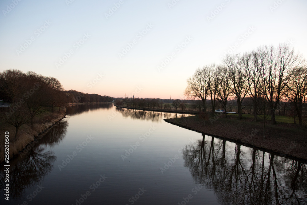 blick auf einen fluss und eine kleines inselufer in fresenburg emsland deutschland fotografiert an einem lauen sommerabend während eines sonnenuntergangs blick auf einen fluss und eine kleines inselufer in fresenburg emsland deutschland fotografiert an einem lauen sommerabend während eines sonnenuntergangs