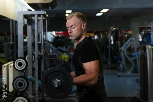 Young man doing the exercises on biceps lifting barbell for good body in fitness gym, bodybuilder, healthy lifestyle, exercise fitness, workout and sport training concept
