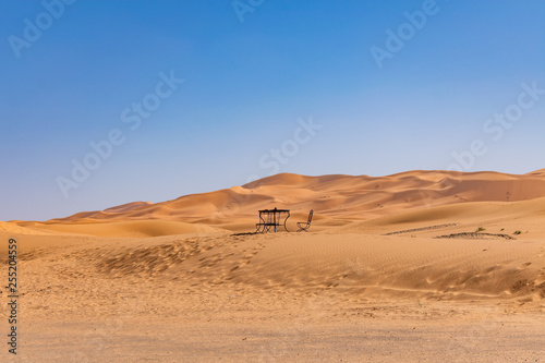 Table and Chair in the distance on a Sand Dune in the Sahara Desert