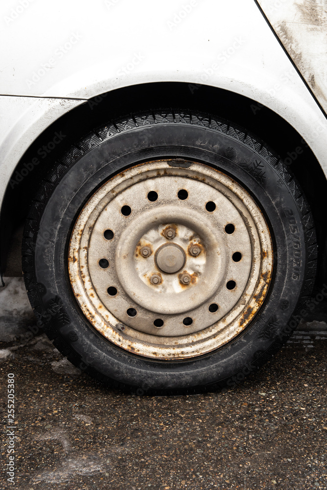 Rusty wheel on the car. This rim will be disposed soon Rusty wheel on the car. This rim will be disposed soon