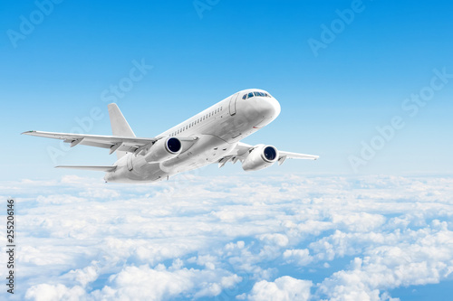Airplane is flying above the day clouds, travel trip vacation. photo