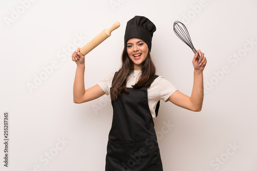Teenager chef over white wall