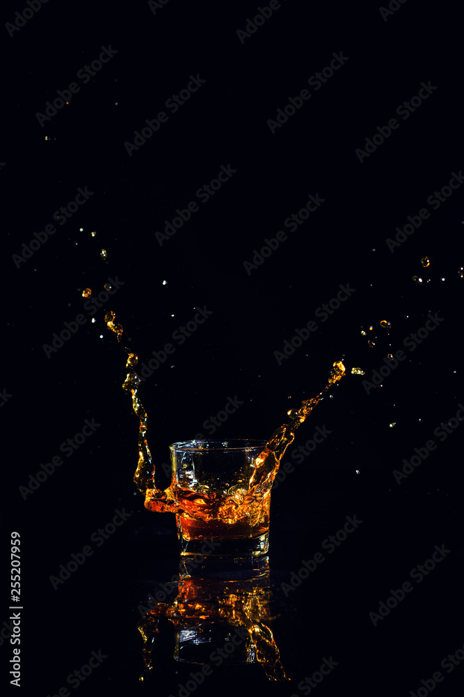 Isolated shot of whiskey with splash on black background