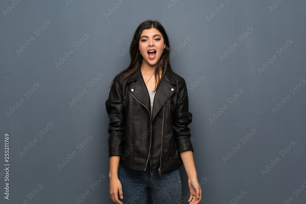 Teenager girl over grey wall with surprise facial expression