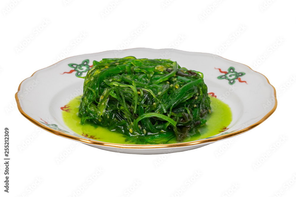 Japanese food. Close-up of Chuka or seaweed salad with sesame seeds on a colorful plate isolated on a white background. Seafood background. Health concept. Japanese food. Close-up of Chuka or seaweed salad with sesame seeds on a colorful plate isolated on a white background. Seafood background. Health concept.
