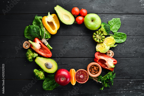 Healthy vegetarian food: avocado, spinach, apple, paprika, parsley, orange, nuts, tomatoes, garlic. Top view free space for your text.