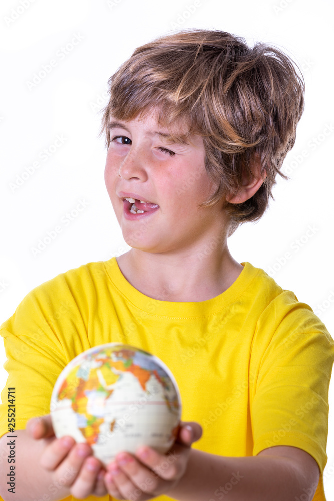 Young boy with yellow T-shirt, aviator goggles, plane and world ball smiling Young boy with yellow T-shirt, aviator goggles, plane and world ball smiling