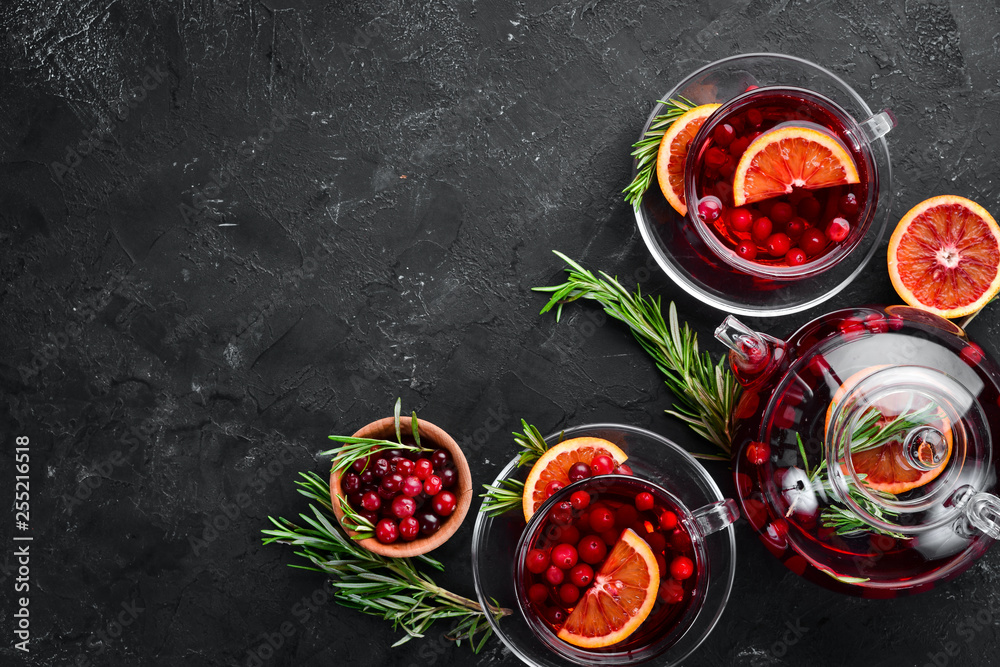 Hot tea with berry cranberry and orange. On the black kitchen background. Top view. Free space for your text. - obrazy, fototapety, plakaty 