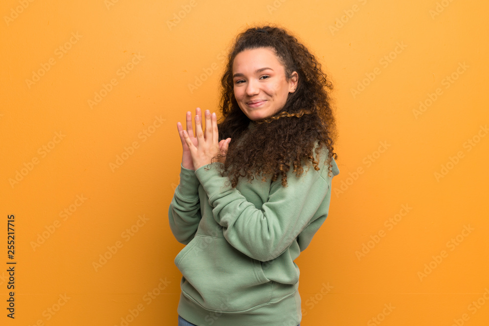 Teenager girl over ocher wall scheming something Teenager girl over ocher wall scheming something