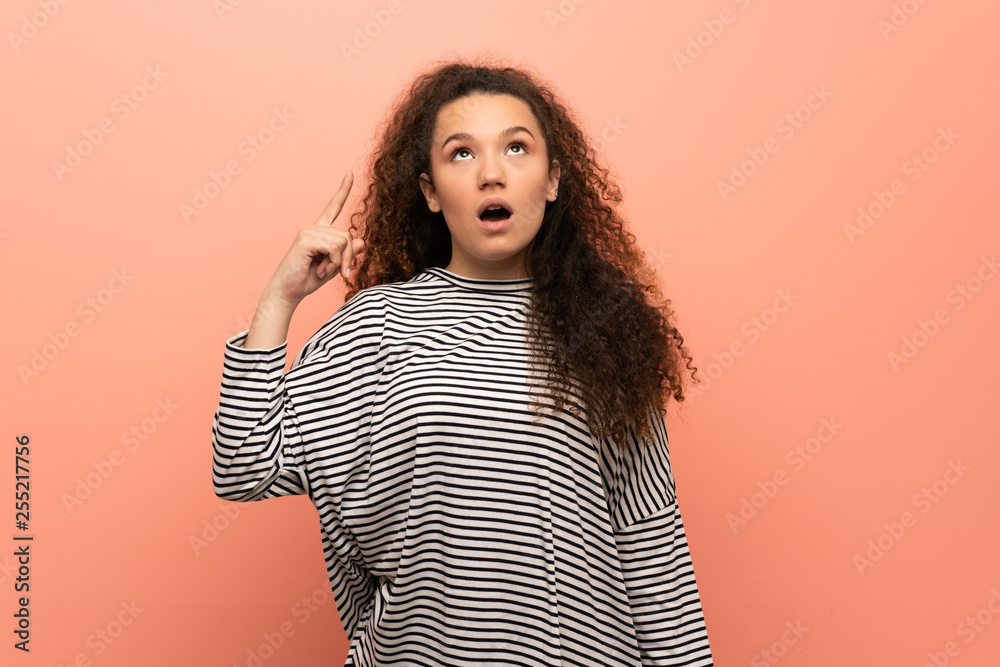 Teenager girl over pink wall thinking an idea pointing the finger up Teenager girl over pink wall thinking an idea pointing the finger up