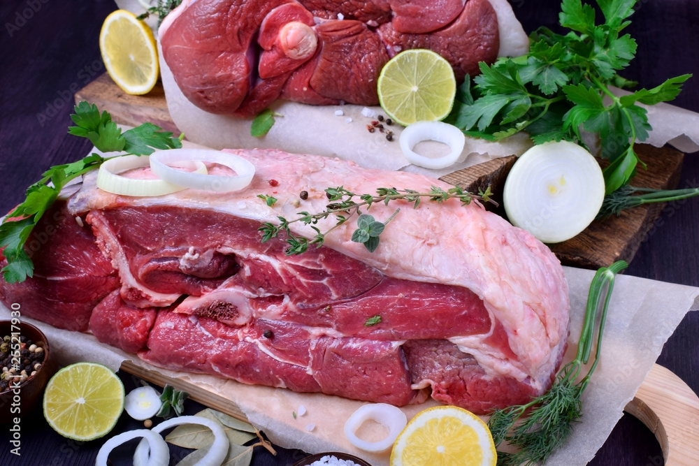 Big piece of raw beef surrounded by spices and herbs