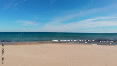 Flying over a lonely beach. Sea is calm and small clouds in the skyFlying over a lonely beach in Denia, Spain. The sea is calm and there's small clouds in the sky photo