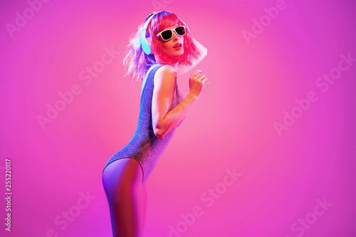 Fashion contemporary neon style. Young graceful woman in party DJ bodysuit dance. Disco summer vibes. Adorable fashionable sexy girl, pink hair, trendy makeup. Creative art pink neon color