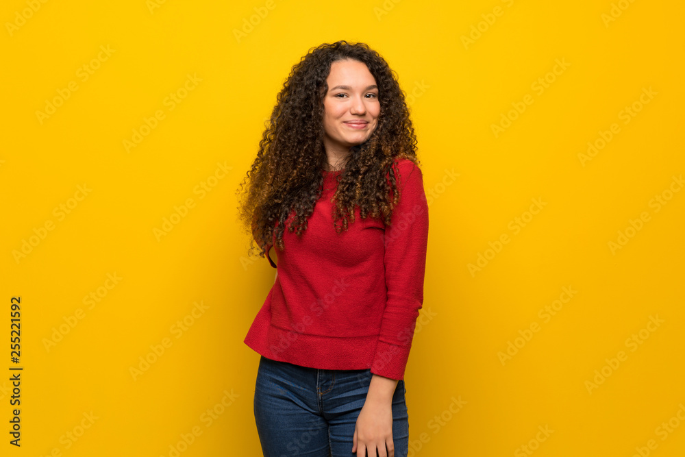 Teenager girl with red sweater over yellow wall Teenager girl with red sweater over yellow wall